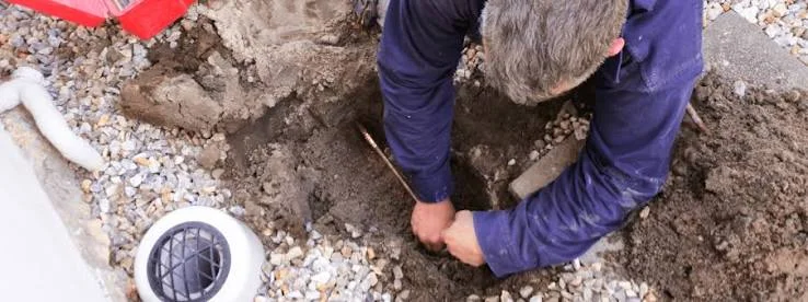 Plumber digging to reach a buried sewer line for a spot repair in a Yorba Linda yard
